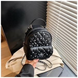 Detail of black quilted mini backpack with rhinestone studs and metal twist lock closure
