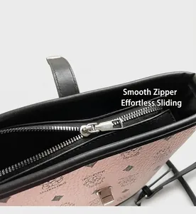 Close-up of a pink leather bucket bag showing smooth metal zipper and litchi texture