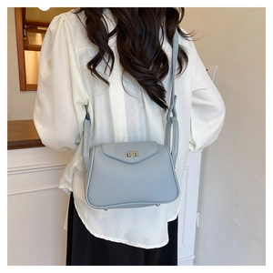 Detailed back view of a light blue lychee pattern leather handbag worn by a model