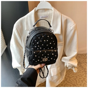 Close-up of quilted black backpack featuring sparkling silver rhinestones and chain strap