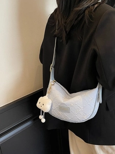 Light blue half-moon crossbody bag with floral texture and white cloud plush charm