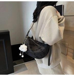 Close-up of black sequined jacquard shoulder bag with a cute cloud plush charm