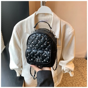 Detail of black quilted mini backpack with sparkling rhinestones and metal chain strap