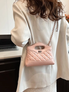 Pink quilted crossbody bag with diamond pattern and silver chain strap on model