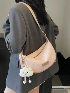 Pink embossed hobo bag with cloud pendant shown on model in grey suit