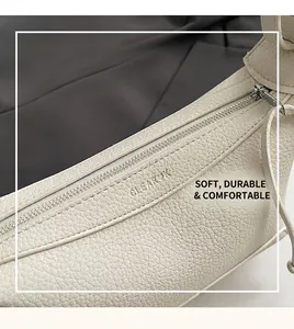 Detail of lychee pattern leather handbag showing top zipper and brand logo
