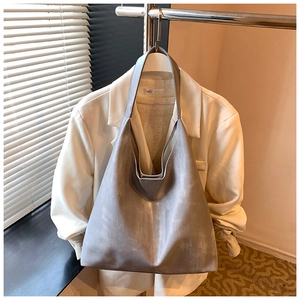 Detail of grey tote bag with washed texture and seamless shoulder strap design