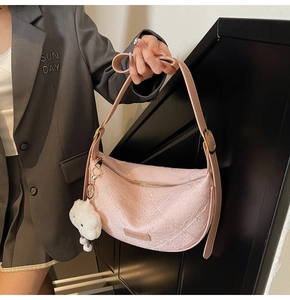 Pink textured hobo bag detail with golden zipper and white fluffy cloud charm accessory