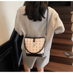 Detail of bear pattern bucket bag featuring a silver buckle and black shoulder strap