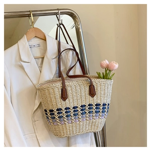 Détail du sac cabas en paille tressée avec motif vague bleu et anses marron