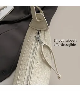 Detail of smooth silver zipper and lychee grain leather on off-white crossbody bag
