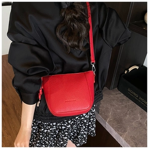 Détail du sac seau rouge vif avec texture grainée et crochet en métal argenté