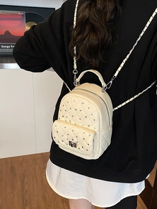 Quilted cream mini backpack with rhinestones and chain straps shown on a model