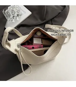 Spacious interior of beige lychee grain leather crescent bag with durable brown lining