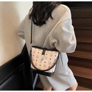 Close-up of beige bucket bag featuring cartoon bear prints and black leather trim