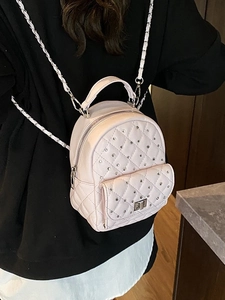 Pale purple quilted mini backpack with rhinestone decor and chain strap on a model