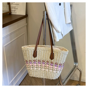 Détail du sac cabas en paille tissée avec rayures colorées et anses en cuir marron