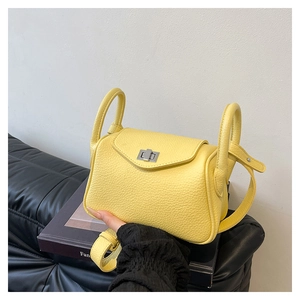 Detail of a bright yellow lychee textured doctor bag with a silver metal swivel lock