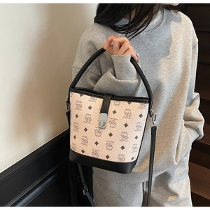 Detail of light pink bucket bag with cartoon bear print and silver metal twist lock