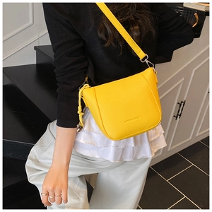 Détail de la texture litchi jaune vif et du lettrage embossé sur le sac seau pour femmes