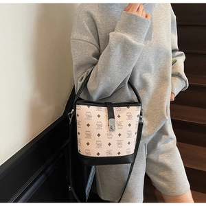 On-body view showing a patterned bucket bag with cartoon tiger and leather strap detail