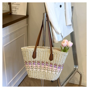 Détail de sac cabas en paille tissé avec motif crochet violet et anses en cuir