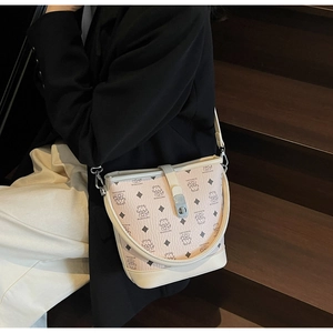 Detailed side view of a pink bucket bag with bear patterns and beige leather trim