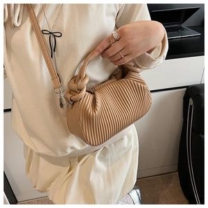 Detail of light brown pleated handbag with vertical ruffles and cylindrical handle
