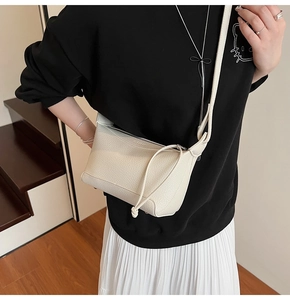 Close-up of cream white lychee texture crossbody bag featuring drawstring design