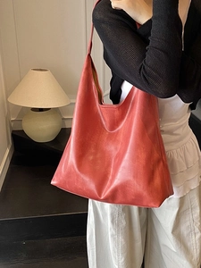 Fashionable large capacity brick red faux leather tote bag worn by model in minimalist interior