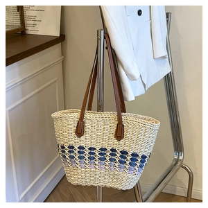 Détail du sac cabas en paille tressée avec motif dégradé violet et anses en cuir