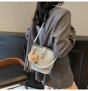 Detail view of light blue lychee pattern bucket bag with cute brown bear keychain