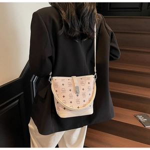 Detail view of pink leather bucket bag with bear print and metal clasp closure