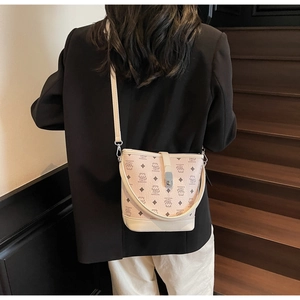 Detail of pink bucket bag featuring teddy bear patterns and metal clasp on shoulder strap