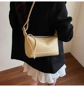 Pale yellow lychee grain shoulder bag styled with a professional black blazer suit