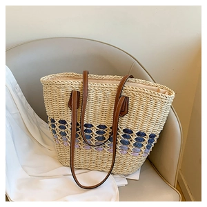 Détail d'un grand sac cabas en paille avec tissage dégradé violet et anses en cuir brun
