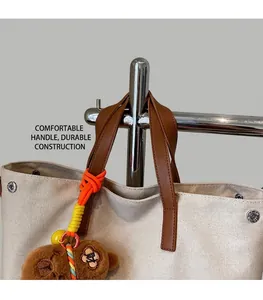 Detail of canvas tote bag with brown leather handles and a cute teddy bear charm