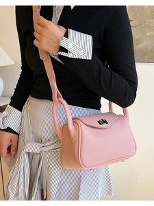 Pink lychee grain leather shoulder bag with metal twist lock shown on a model