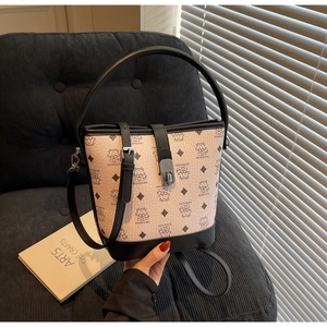 Detail of pink and black bucket bag with bear print and silver metal buckle on a sofa