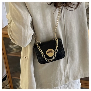 Detail shot of black crocodile embossed girls mini bag with gold hardware and chain strap