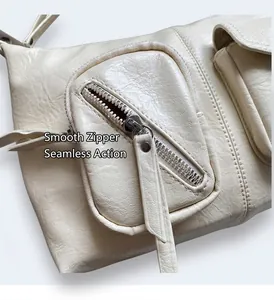 Detail of silver zipper pocket on cream leather tote with natural crinkled texture