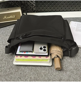 Internal view of a black tactical messenger bag showing large capacity for tablets and books