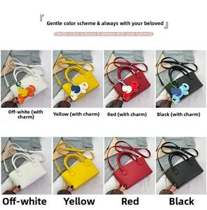 Detail view of leather crossbody bucket bags in multiple colors with cute elephant charms