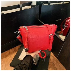 Détail du sac seau en cuir grainé rouge avec zip argenté et pendentif coeur