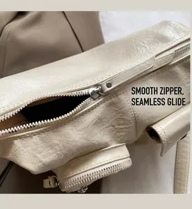 Detailed close-up of smooth silver metal zipper and lychee grain leather on underarm bag
