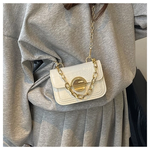 Detail of white crocodile pattern mini bag with gold chain strap and metal clasp