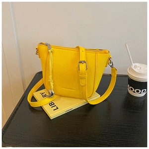 Détail du sac seau en cuir jaune avec boucles argentées et gaufrage de mode
