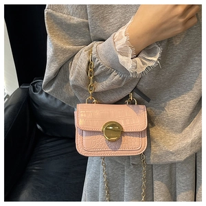 Detail of light pink crocodile pattern girls handbag with golden metal twist lock