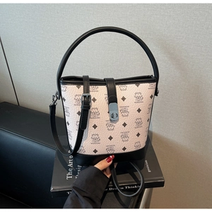 Detail of black and white bucket bag with monster pattern and blue metal lock