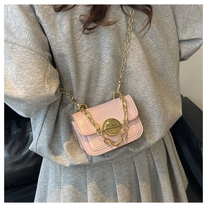 Detail of pink croc-embossed girl's mini shoulder bag with gold heart lock and chain strap